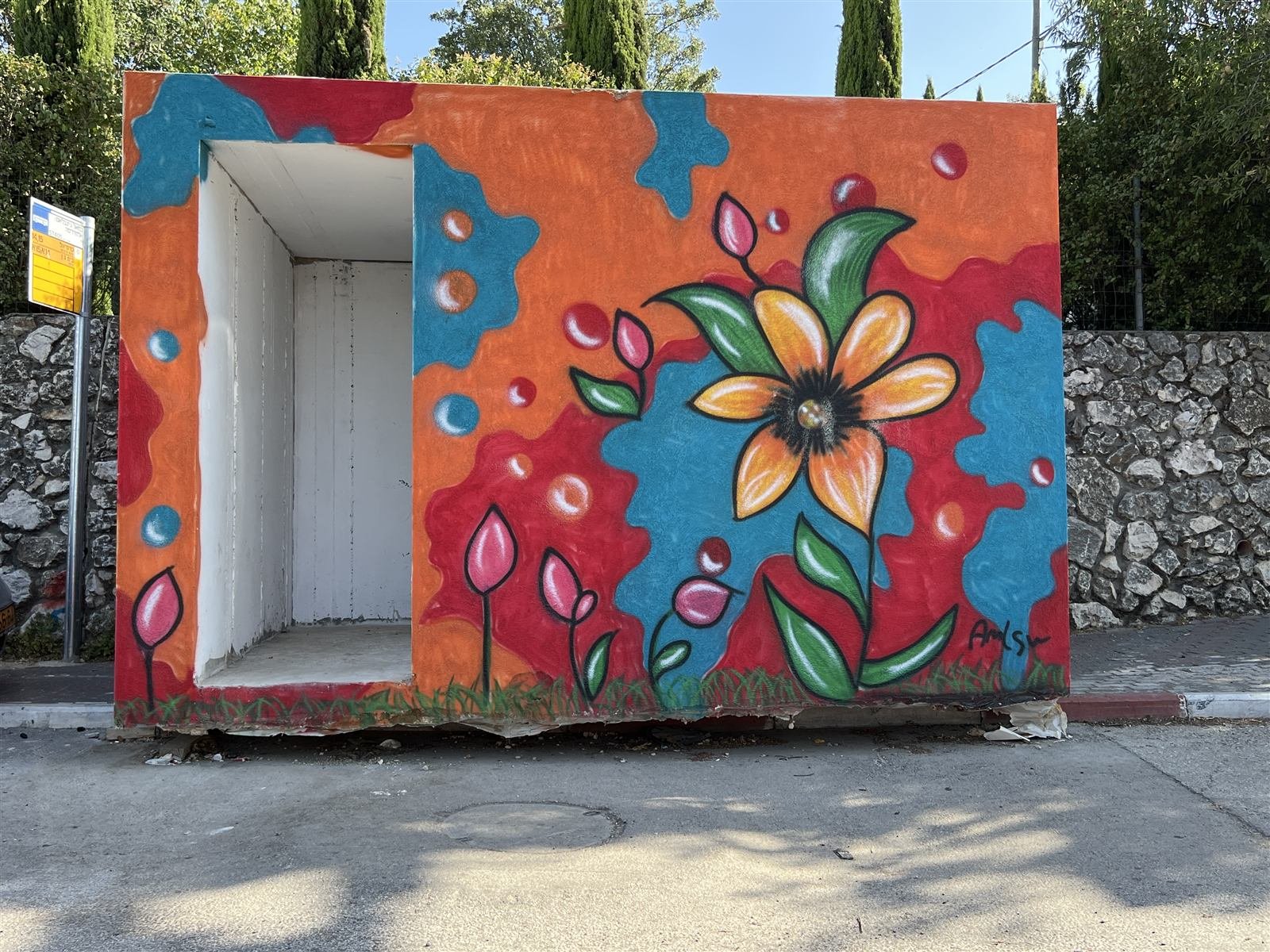 A public shelter painted with a bright flower mural