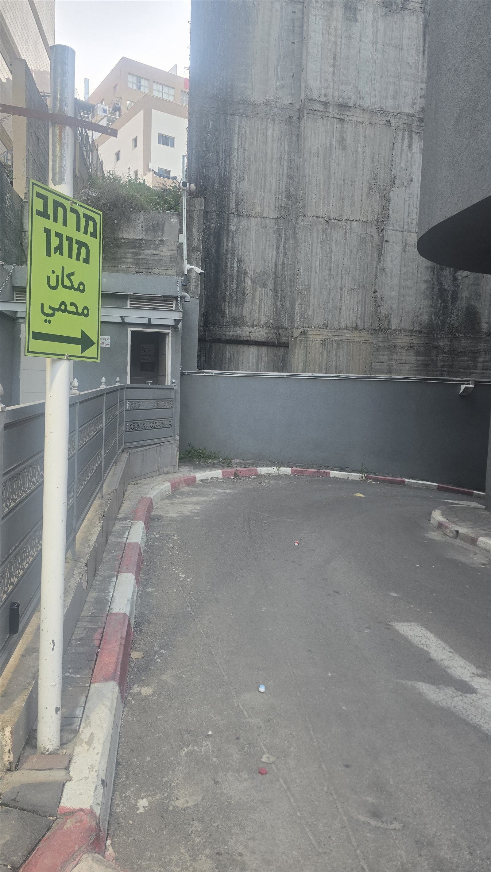 Bilingual protected-space sign pointing to a shelter entrance